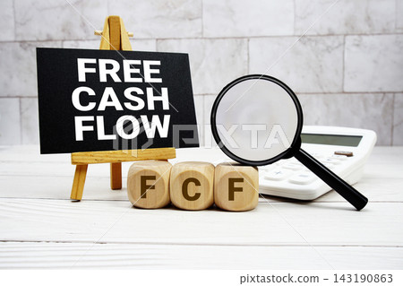 FCF Free Cash Flow text with calculator magnifying glass and on wooden background FCF Free Cash Flow text with calculator magnifying glass and on wooden background 143190863