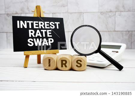 IRS Interest Rate Swap text with calculator magnifying glass and on wooden background IRS Interest Rate Swap text with calculator magnifying glass and on wooden background 143190885