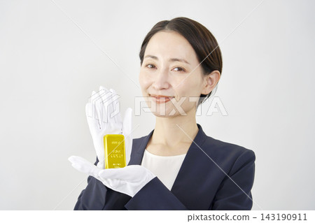 女性鑑定師手持金條，白色背景 143190911