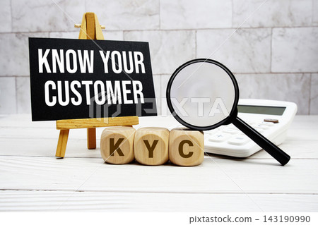 KYC Know Your Customer text with calculator magnifying glass and on wooden background KYC Know Your Customer text with calculator magnifying glass and on wooden background 143190990