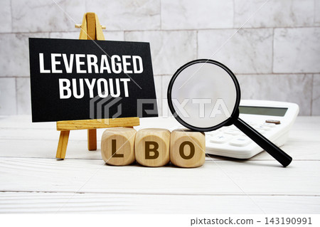LBO Leveraged Buyout text with calculator magnifying glass and on wooden background 143190991