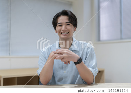 一個年輕人看著鏡頭微笑 一個年輕人看著鏡頭微笑 143191324