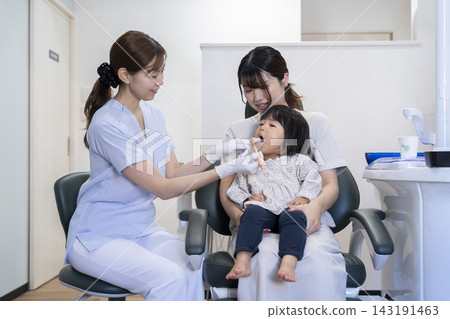 A 2-year-old girl and her mother receiving toothbrushing instruction at a dental clinic. A 2-year-old girl and her mother receiving toothbrushing instruction at a dental clinic. 143191463