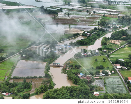 Mist blankets an aerial view of the swollen Khlong Yang canal overflowing into rural rice fields in Uthai Thani. Mist blankets an aerial view of the swollen Khlong Yang canal overflowing into rural rice fields in Uthai Thani. 143191654
