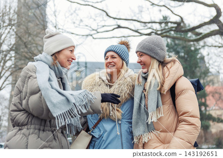 Three cheerful young adult women friend walk Magdeburg street old european uk german town city street enjoy having fun laughing cold winter day together. Female persons friendship celebration weekend Three cheerful young adult women friend walk Magdeburg street old european uk german town city street enjoy having fun laughing cold winter day together. Female persons friendship celebration weekend 143192651
