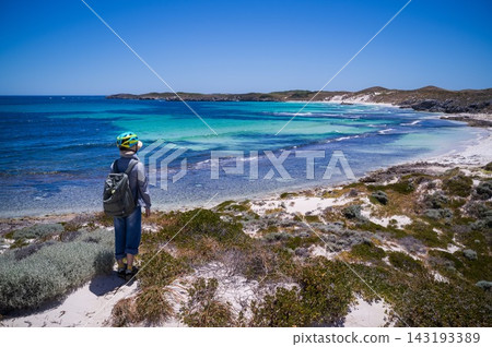 一位旅行者站在羅特內斯特島的山頂上,眺望著碧綠的大海。 一位旅行者站在羅特內斯特島的山頂上,眺望著碧綠的大海。 143193389