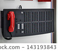 Control panel with buttons and a red phone in a modern setting 143193843