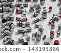 Different types of metal and plastic fittings are arranged on a white surface for display and inspection 143193866
