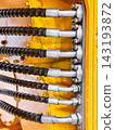 Close-up view of hydraulic hoses and fittings on heavy machinery in an industrial setting 143193872