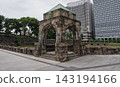 A stone gazebo in the Imperial Palace Outer Garden, along the Babasaki moat, with towering skyscrapers in the background. 143194166