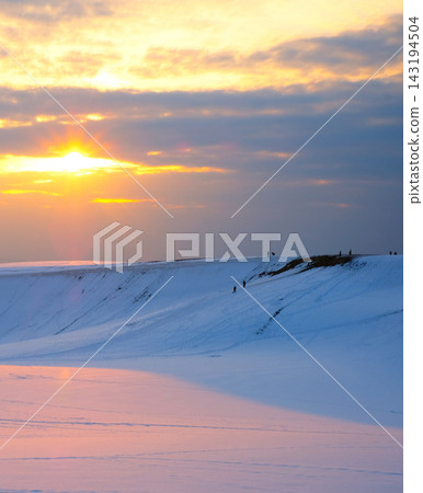 夕陽西下,橙紅色的光芒籠罩著鳥取沙丘的雪景 夕陽西下,橙紅色的光芒籠罩著鳥取沙丘的雪景 143194504