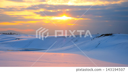 夕陽西下,橙紅色的光芒籠罩著鳥取沙丘的雪景 夕陽西下,橙紅色的光芒籠罩著鳥取沙丘的雪景 143194507
