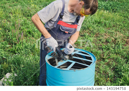 Man safety goggles and gloves, cutting metal for DIY upcycling project outdoors Man safety goggles and gloves, cutting metal for DIY upcycling project outdoors 143194758