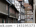 Historic street in Goslar, Germany is lined with traditional half timbered houses and slate facades. Autumn scenery highlights medieval architecture, heritage, charm and old European town atmosphere 143195373