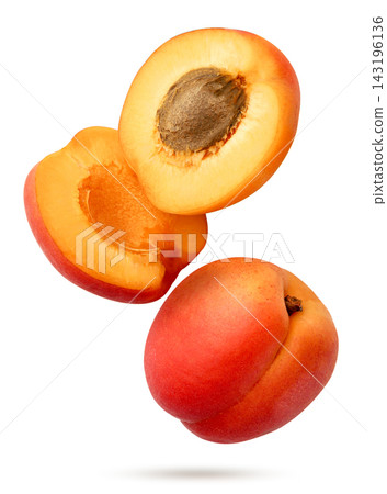 A ripe apricot and two halves flying close-up on a white background. Isolated A ripe apricot and two halves flying close-up on a white background. Isolated 143196136