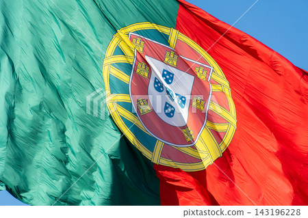 Extreme close up of the Portuguese coat of arms on a large waving national flag Extreme close up of the Portuguese coat of arms on a large waving national flag 143196228