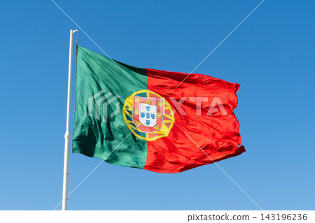 Portuguese flag waving on flagpole against clear blue sky in Lisbon Portuguese flag waving on flagpole against clear blue sky in Lisbon 143196236
