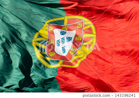 Macro texture of a large waving Portuguese flag with the national coat of arms Macro texture of a large waving Portuguese flag with the national coat of arms 143196241