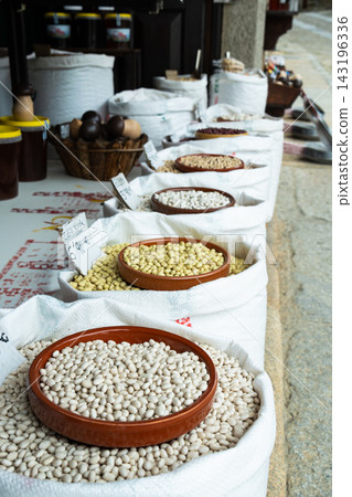 Outdoor market display with rows of white sacks filled with dried beans, legumes Outdoor market display with rows of white sacks filled with dried beans, legumes 143196336