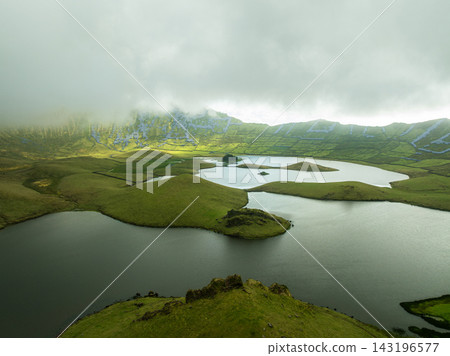 Aerial view of Caldeirao volcanic crater lake with rolling clouds, Corvo Island Aerial view of Caldeirao volcanic crater lake with rolling clouds, Corvo Island 143196577