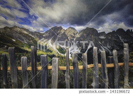 Mountain landscape with rocky peaks and wooden railing 143196672