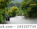 A motorcycle riding through autumn foliage 143197734