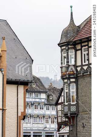 Historic Goslar center features ornate red facade, half timbered houses and autumn trees. Medieval architecture, decorative figures and colorful streetscape create charming German heritage atmosphere Historic Goslar center features ornate red facade, half timbered houses and autumn trees. Medieval architecture, decorative figures and colorful streetscape create charming German heritage atmosphere 143198483