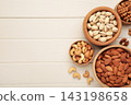 Mixed nuts in wooden bowls on light wooden background. Almonds, pistachio, walnuts, cashew, hazelnut. Space for text 143198658