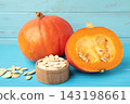 Sliced Hokkaido pumpkin with seeds on bowl on blue background. 143198661