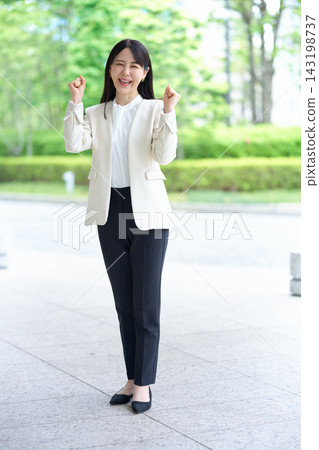 一位身穿西裝的女士全身照,雙手做出勝利的手勢。 一位身穿西裝的女士全身照,雙手做出勝利的手勢。 143198737