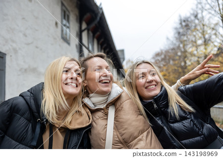 Cheerful friends laugh together on autumn city walk, sharing hugs and joyful travel moments. Candid group portrait captures friendship, reunion, happiness, leisure and weekend adventure outdoors Cheerful friends laugh together on autumn city walk, sharing hugs and joyful travel moments. Candid group portrait captures friendship, reunion, happiness, leisure and weekend adventure outdoors 143198969
