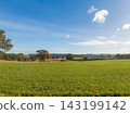 Idyllic rural English landscape with green meadow under a blue sky on a sunny day 143199142