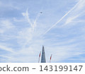 Modern Glass Skyscraper Construction with Cranes and Airplane 143199147
