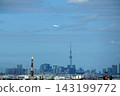 一架飛機從煉油廠熊熊燃燒的煙囪和東京晴空塔之間穿過，緩緩升空。 143199772