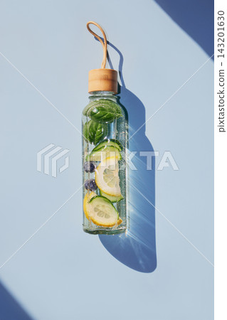 Reusable glass bottle filled with refreshing infused water, promoting healthy hydration and wellness Reusable glass bottle filled with refreshing infused water, promoting healthy hydration and wellness 143201630