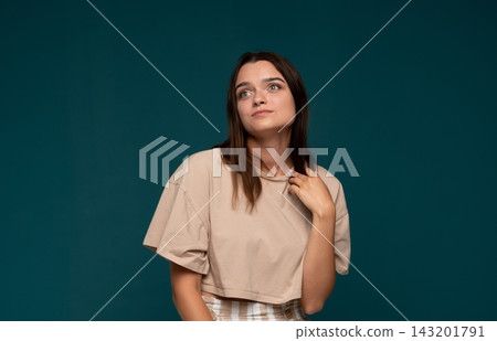 Young woman thinking, looking up with a thoughtful expression, having an idea on green background Young woman thinking, looking up with a thoughtful expression, having an idea on green background 143201791