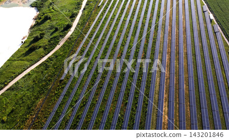 Solar farm generating clean renewable energy from sunlight, aerial view of photovoltaic panels next to a river Solar farm generating clean renewable energy from sunlight, aerial view of photovoltaic panels next to a river 143201846
