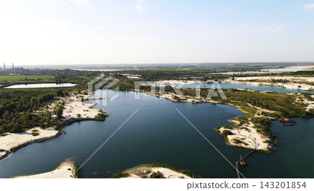 Landscape of a sand and gravel quarry operation with industrial equipment and facilities for extraction and processing visible Landscape of a sand and gravel quarry operation with industrial equipment and facilities for extraction and processing visible 143201854