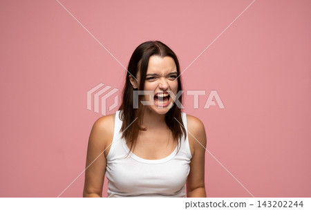 Angry young woman screaming, expressing frustration and rage, shouting with aggression on pink background Angry young woman screaming, expressing frustration and rage, shouting with aggression on pink background 143202244