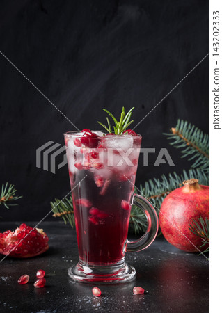 Pomegranate Holiday cocktail with rosemary sprig, sparkling wine on black. Pomegranate Holiday cocktail with rosemary sprig, sparkling wine on black. 143202333
