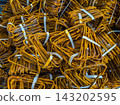 Close-Up of Rusty Steel Rebar Bundles Tied With Straps 143202595