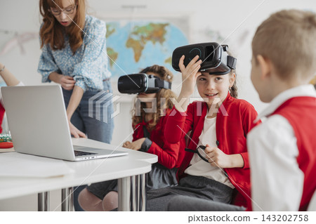 Primary school students exploring virtual reality during technology class. Primary school students exploring virtual reality during technology class. 143202758