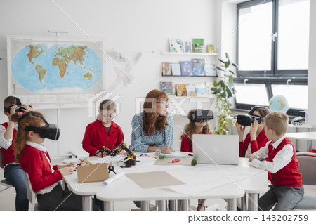 Primary school students exploring virtual reality during technology class. 143202759