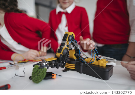 Primary school students learning robotics and technology during STEM class. Primary school students learning robotics and technology during STEM class. 143202770