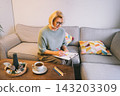 Woman drawing work-life balance wheel sitting on the sofa at home. Self-reflection and life planning for next new year. Personal Year review. Coaching tools. Finding Balance in Life. Selective focus 143203309