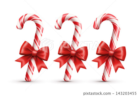 Three classic red striped candy canes with red ribbon bows on a white background. Three classic red striped candy canes with red ribbon bows on a white background. 143203455