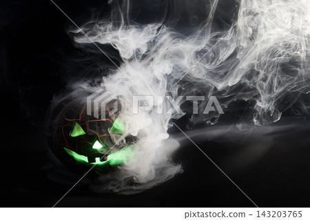 Halloween jack-o'-lantern glowing green with smoke Halloween jack-o'-lantern glowing green with smoke 143203765