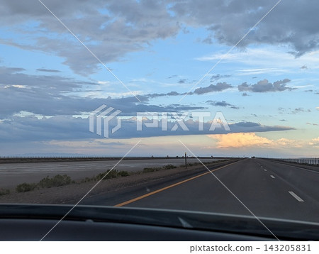 Driving on I-80 Away From Bonneville Salt Flats at Sunset with Stunning Skies Driving on I-80 Away From Bonneville Salt Flats at Sunset with Stunning Skies 143205831