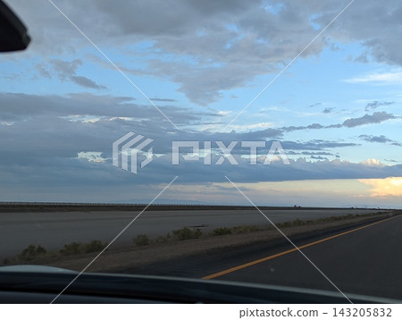 Driving on I-80 Away From Bonneville Salt Flats at Sunset with Stunning Skies Driving on I-80 Away From Bonneville Salt Flats at Sunset with Stunning Skies 143205832