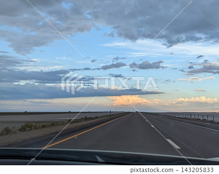 Driving on I-80 Away From Bonneville Salt Flats at Sunset with Stunning Skies 143205833